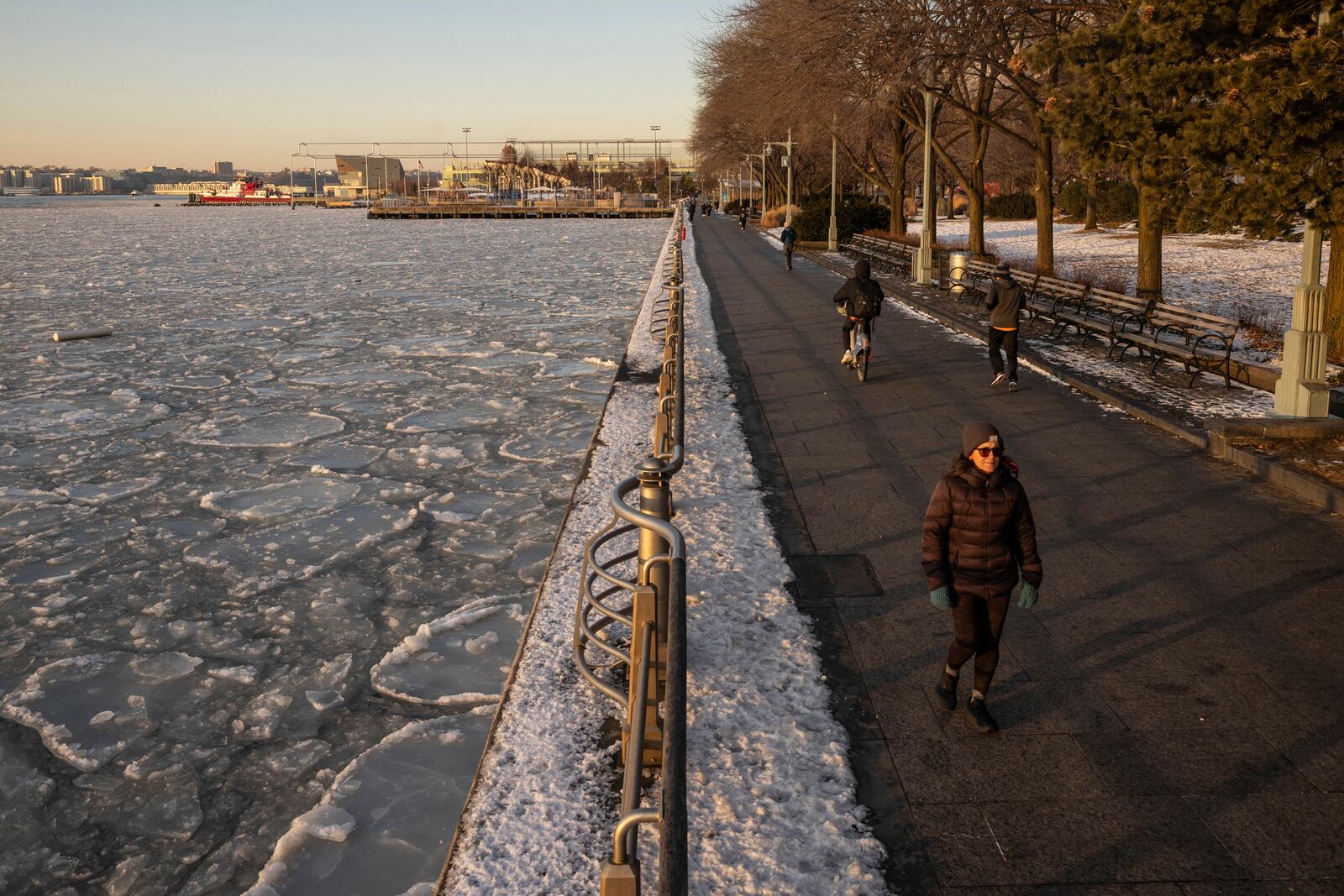 People walk along the Hudson River as it's covered by ice, Thursday, Jan. 23, 2025, in New York. (AP Photo/Yuki Iwamura)