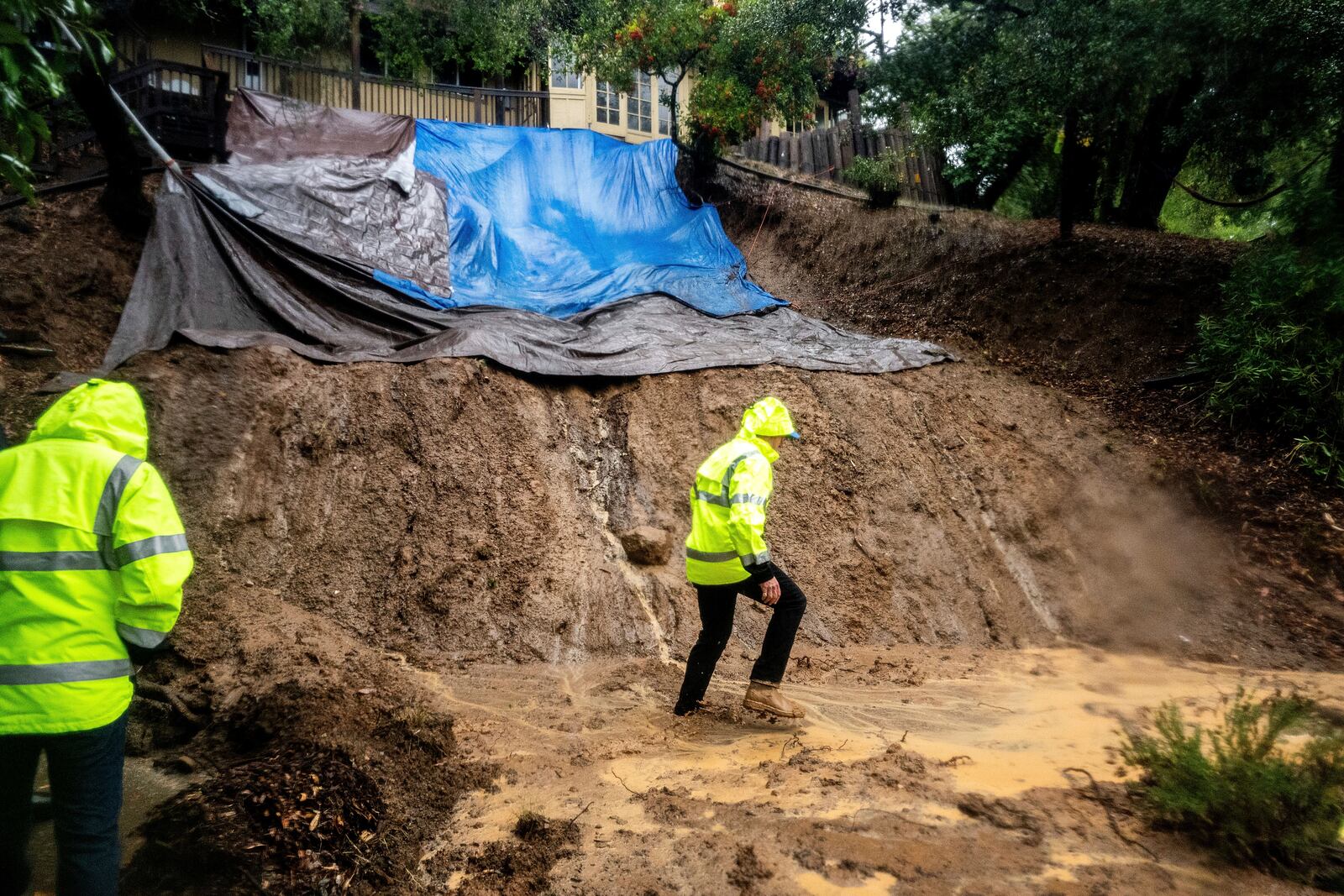 FILE - Permit Sonoma Director Tennis Wick crosses a mudslide to inspect a home as heavy rains fall near Healdsburg in unincorporated Sonoma County, Calif., Nov. 22, 2024. (AP Photo/Noah Berger, File)