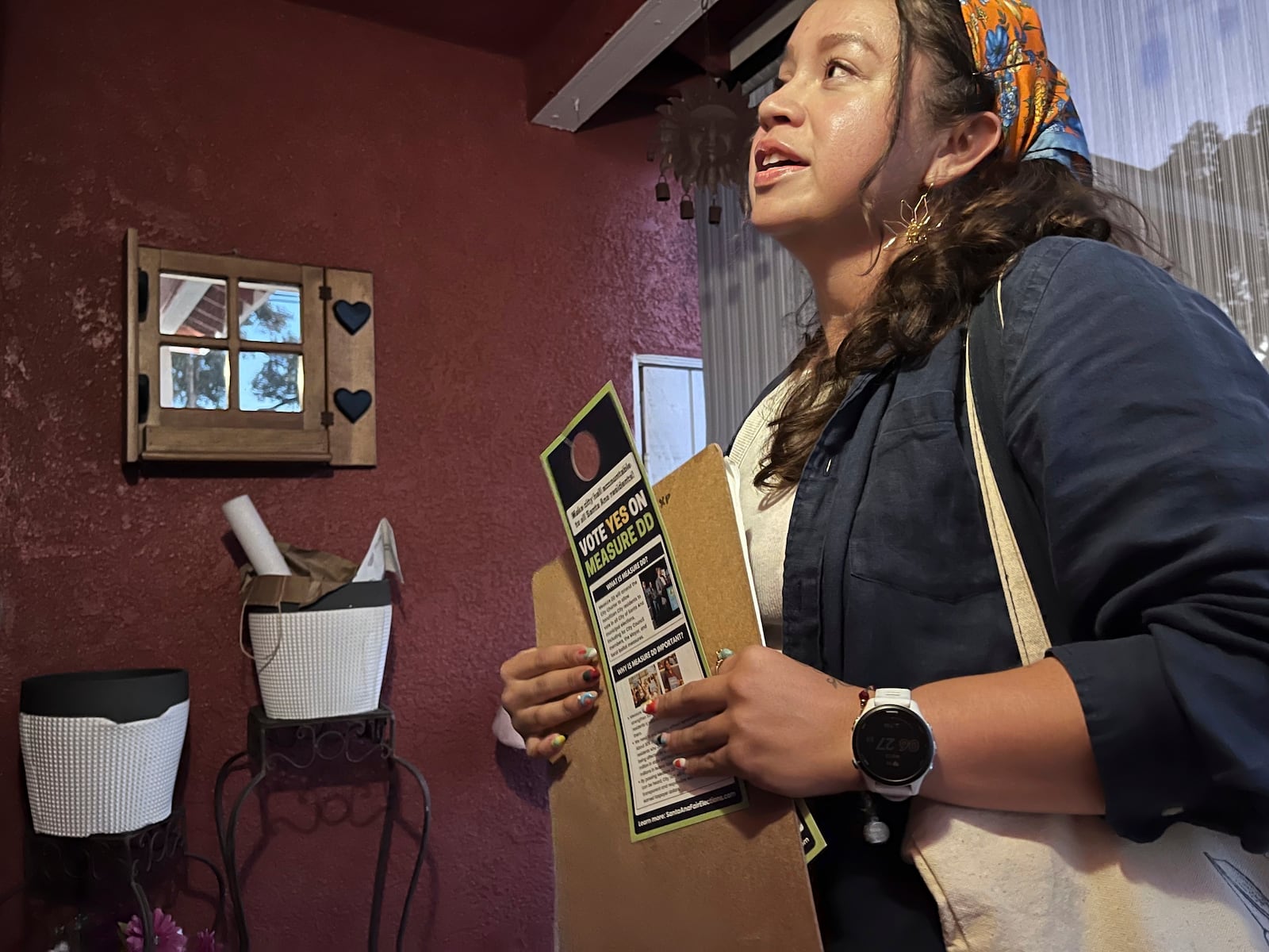 FILE - Tania Ortega, 27, speaks with a Santa Ana, Calif. resident on Wednesday, Oct. 23, 2024, about Measure DD, which would allow noncitizens to vote in local elections. (AP Photo/Jaimie Ding, File)