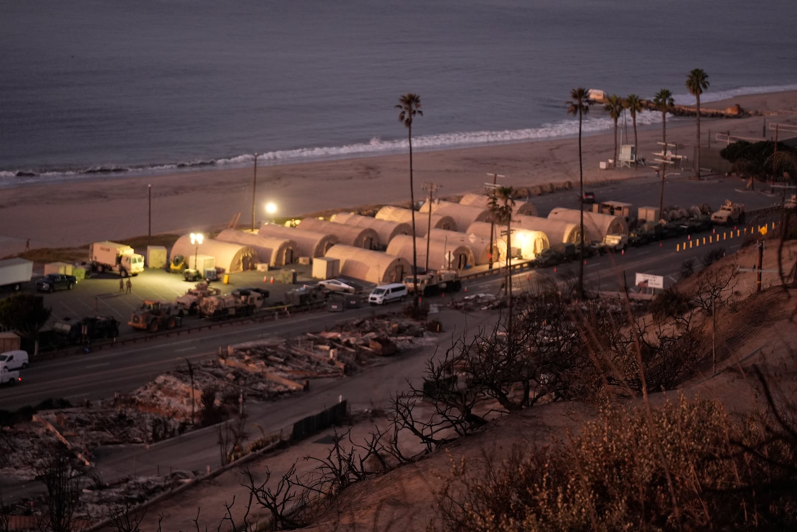 Members of the National Guard camp are across homes destroyed by the Palisades Fire in the Pacific Palisades neighborhood of Los Angeles, Thursday, Jan. 16, 2025. (AP Photo/Damian Dovarganes)