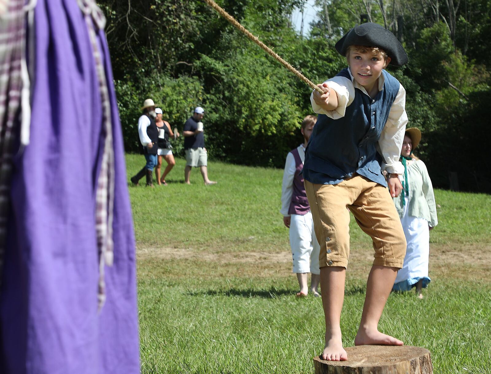 James Hartzler and Lili Roberts try to pull each other of the stumps they were standing on as they play a game at the Fair at New Boston last summer. BILL LACKEY/STAFF