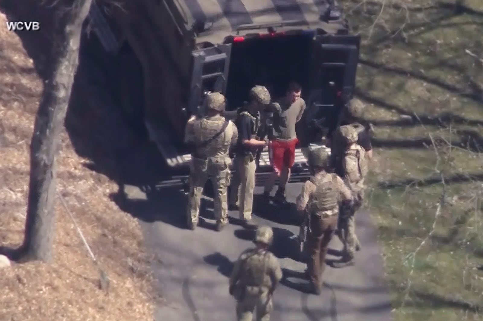 This image made from video provided by WCVB-TV, shows Jack Teixeira, in T-shirt and shorts, being taken into custody by armed tactical agents on Thursday, April 13, 2023, in Dighton, Mass. (WCVB-TV via AP, File)