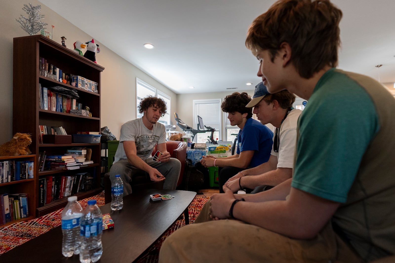 From left, high school seniors Ari Cohen, Nathaniel Durham, Abe Garry and Mason Cooke play a game of Uno in Cohen's living room, Friday, Oct. 18, 2024, in Asheville, N.C. (AP Photo/Stephanie Scarbrough)