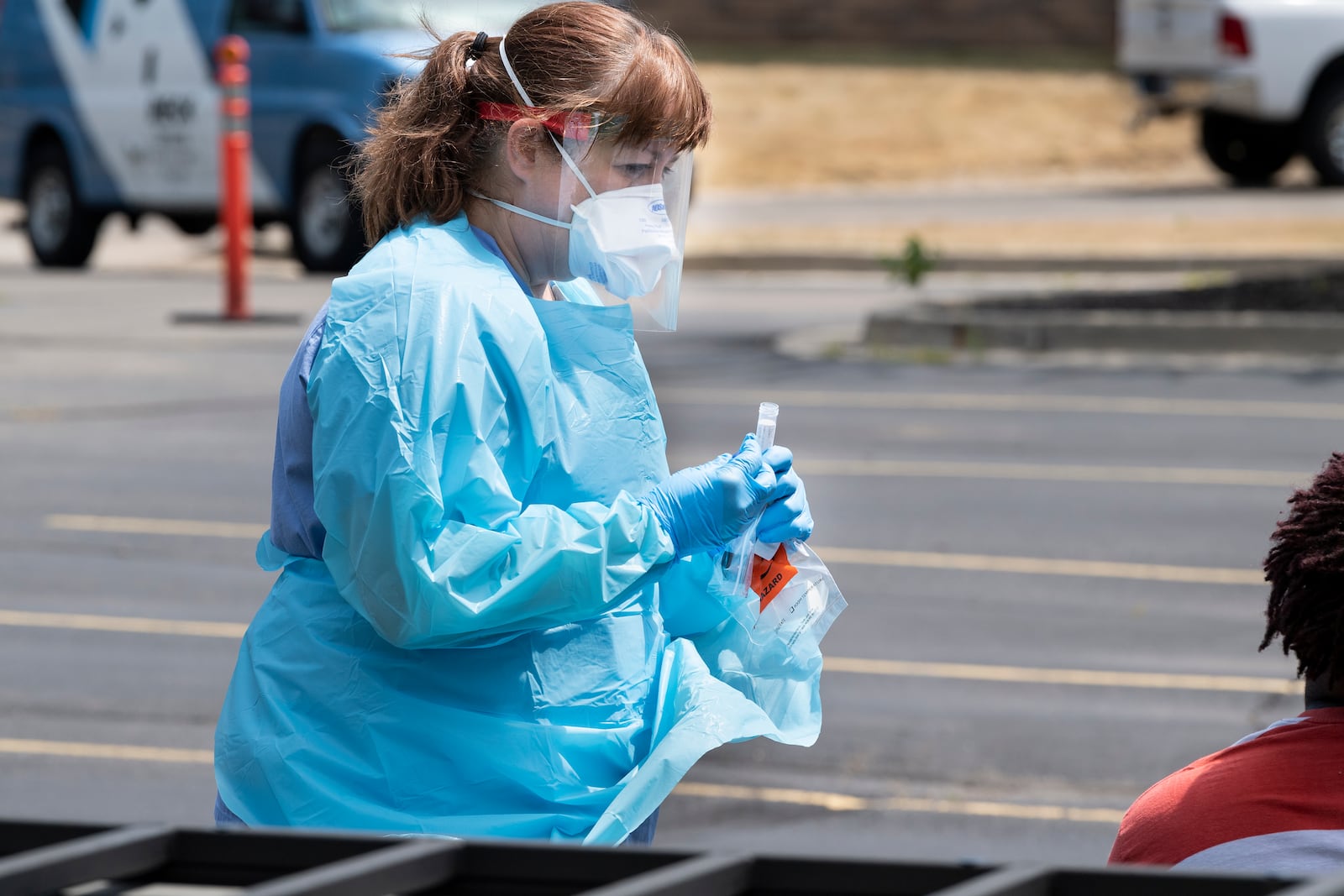 A nurse at one a Kettering Health Network drive-thru clinics from earlier this year prepares to swab a patient's nose for a COVID-19 test.