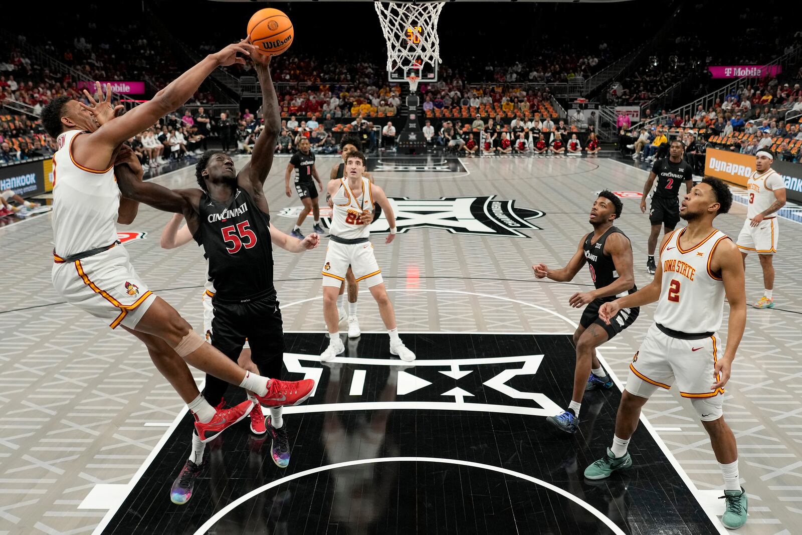 Cincinnati forward Aziz Bandaogo (55) shoots under pressure from Iowa State center Dishon Jackson, left, during the first half of an NCAA college basketball game in the Big 12 men's tournament Wednesday, March 12, 2025, in Kansas City, Mo. (AP Photo/Charlie Riedel)