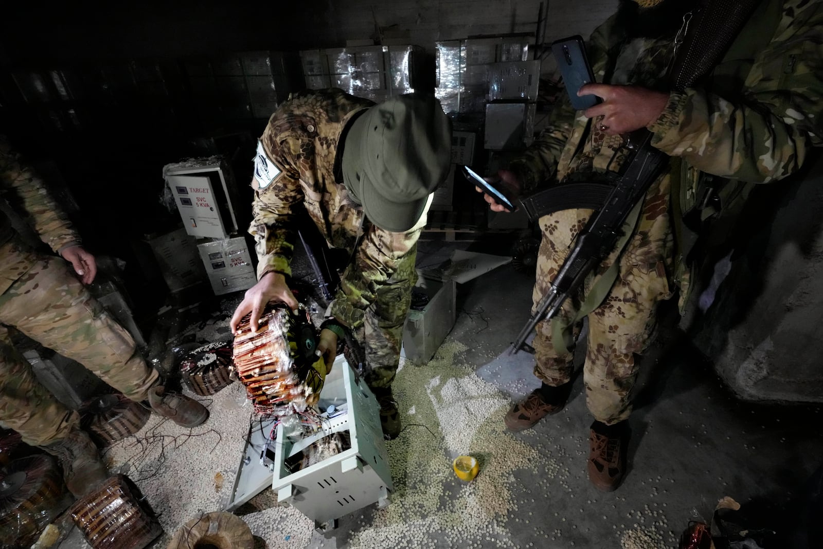 A Syrian member of the rebel group unloads amphetamine pills, known as Captagon, hidden inside an electrical component at the warehouse where the drug was manufactured before the fall of Bashar Assad government at a facility in Douma city, outskirts of Damascus, Syria, Friday, Dec. 13, 2024. (AP Photo/Hussein Malla)