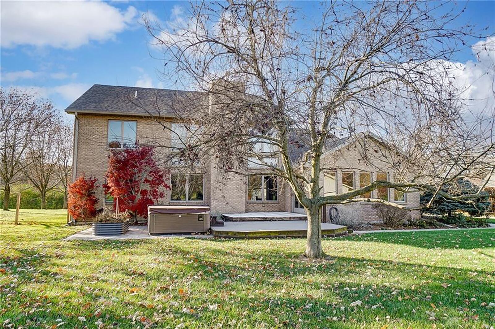 The rear of the home has a two-tiered composite deck with a hot tub on a concrete patio. CONTRIBUTED 