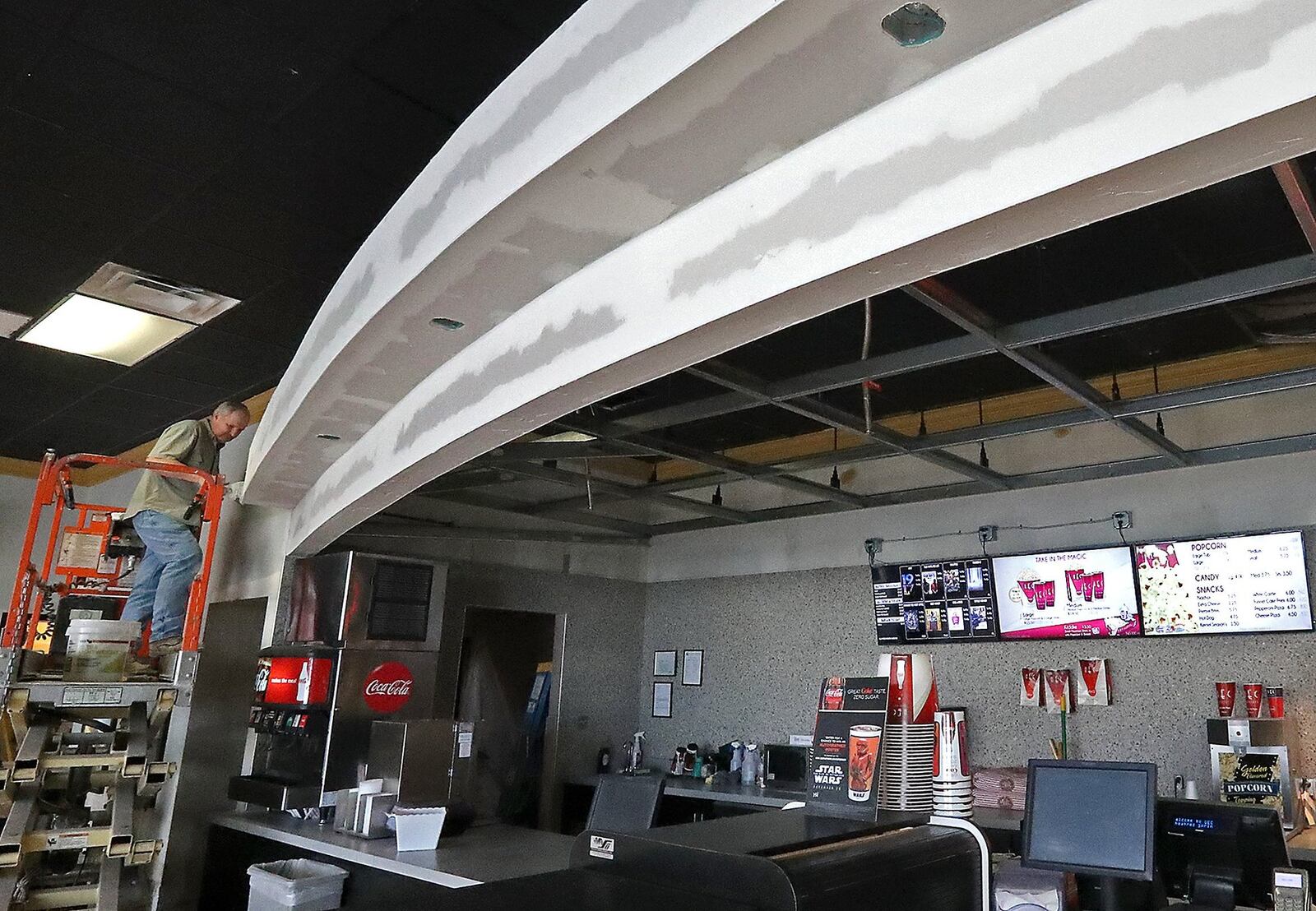 A contractor works on the new concession area Thursday at the UEC Theaters Cinema 10 in Springfield. Springfield’s only movie theater is undergoing an extensive renovation including putting reclining seats in all the theaters and updating the lobby and restrooms. BILL LACKEY/STAFF