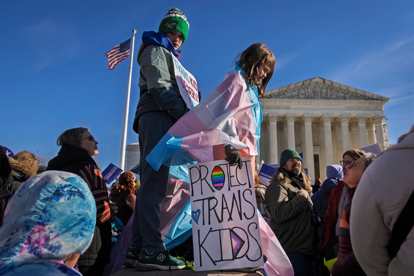 FILE - Nate, 14, left, and Bird, 9, right, hold signs and transgender pride flags as supporters rally outside the Supreme Court, Dec. 4, 2024, in Washington, while arguments are underway in a case regarding a Tennessee law banning gender-affirming medical care for transgender youth. (AP Photo/Jacquelyn Martin, File)