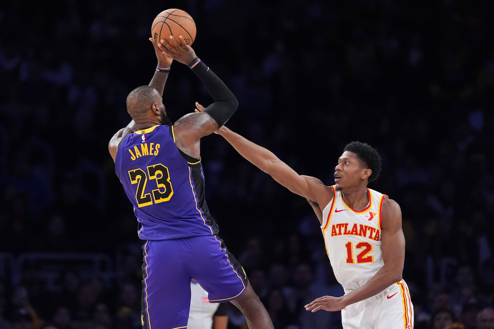 Los Angeles Lakers forward LeBron James, left, shoots as Atlanta Hawks forward De'Andre Hunter defends during the second half of an NBA basketball game, Friday, Jan. 3, 2025, in Los Angeles. (AP Photo/Mark J. Terrill)