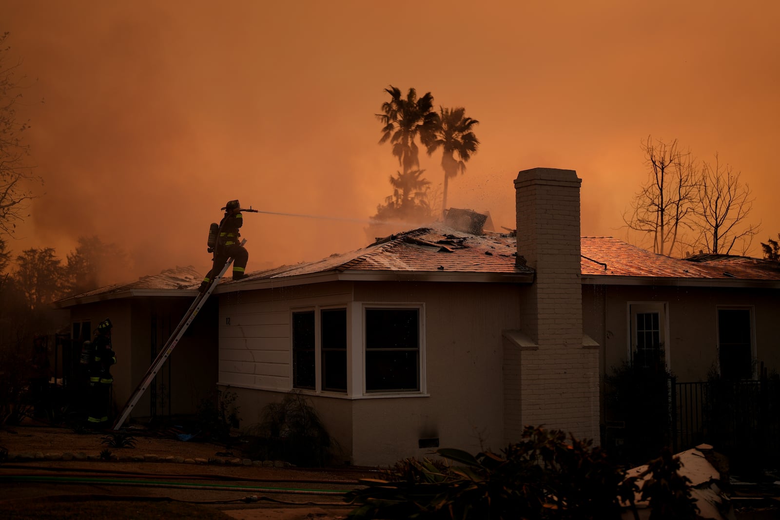 FILE - Fire crews battle the Eaton Fire as it impacts a structure Jan. 9, 2025, in Altadena, Calif. (AP Photo/Eric Thayer, File)