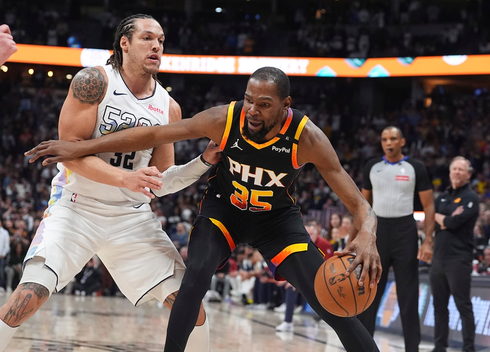 Phoenix Suns forward Kevin Durant (35) drives past Denver Nuggets forward Aaron Gordon in overtime of an NBA basketball game Friday, March 7, 2025, in Denver. (AP Photo/David Zalubowski)