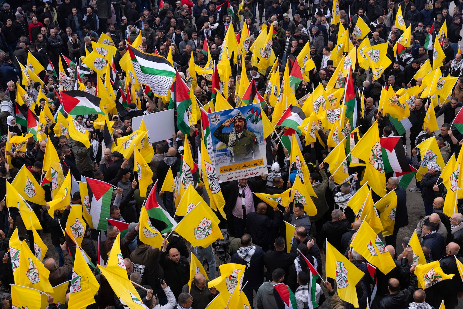 Palestinians hold yellow Fatah movement flags as they demonstrate in support of the Palestinian security forces in the Jenin refugee camp in the Israeli-occupied West Bank, Sunday, Dec. 29, 2024. (AP Photo/Majdi Mohammed)