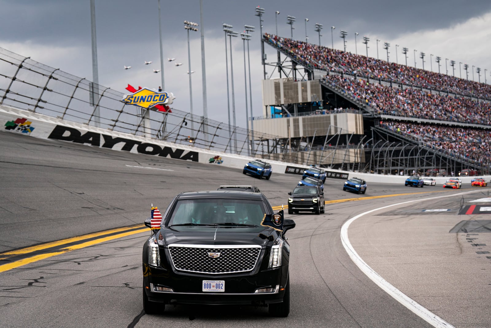 President Donald Trump rides in the presidential limousine known as "The Beast" as he takes a pace lap ahead of the start of the NASCAR Daytona 500 auto race at Daytona International Speedway, Sunday, Feb. 16, 2025, in Daytona Beach, Fla. (Pool via AP)