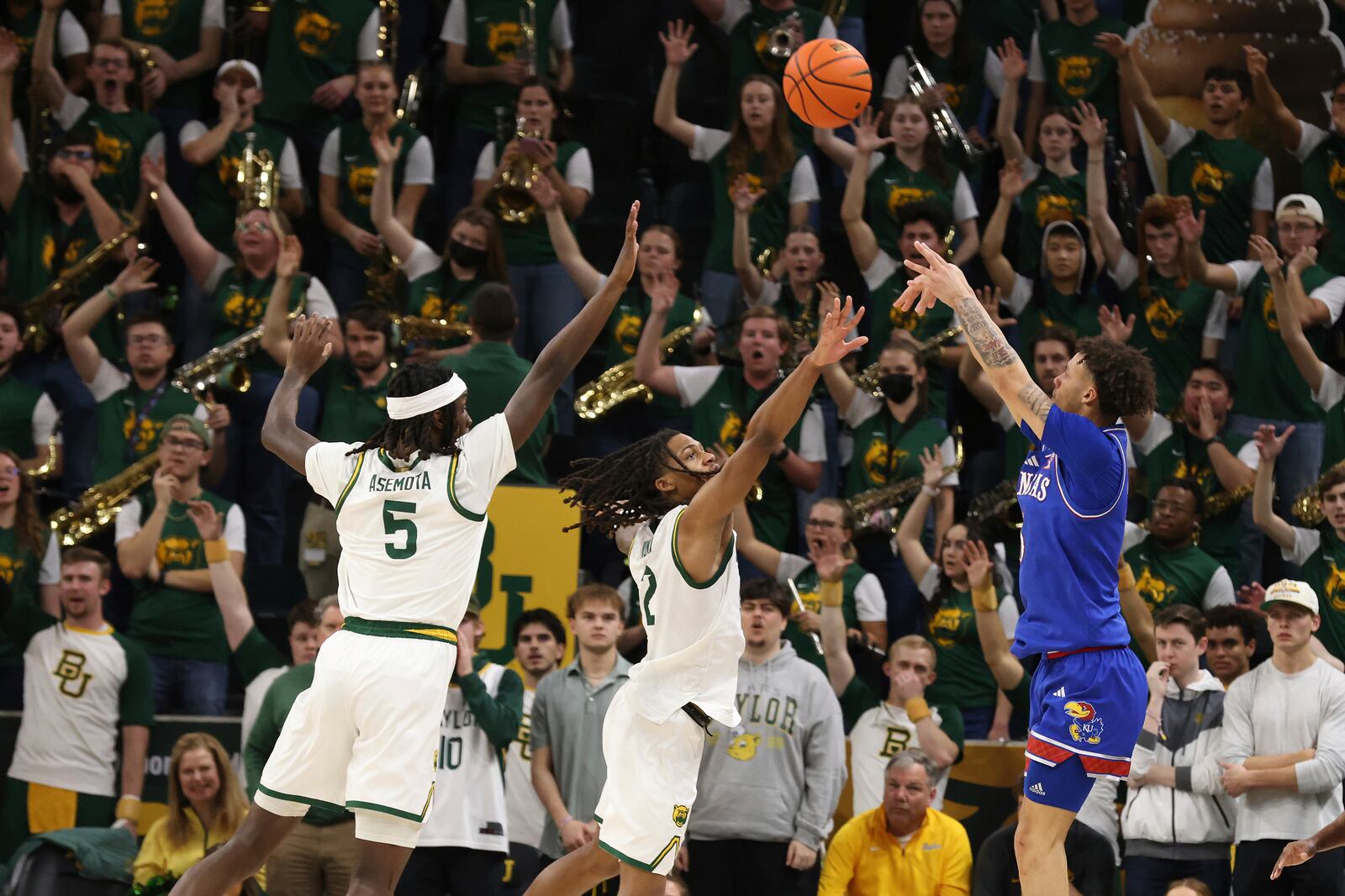 Kansas guard Zeke Mayo, right, attempts a 3-point shot over Baylor guard Jayden Nunn, center and forward Jason Asemota, left, during the second half of an NCAA college basketball game Saturday, Feb. 1, 2025, in Waco, Texas. (AP Photo/Jerry Larson)