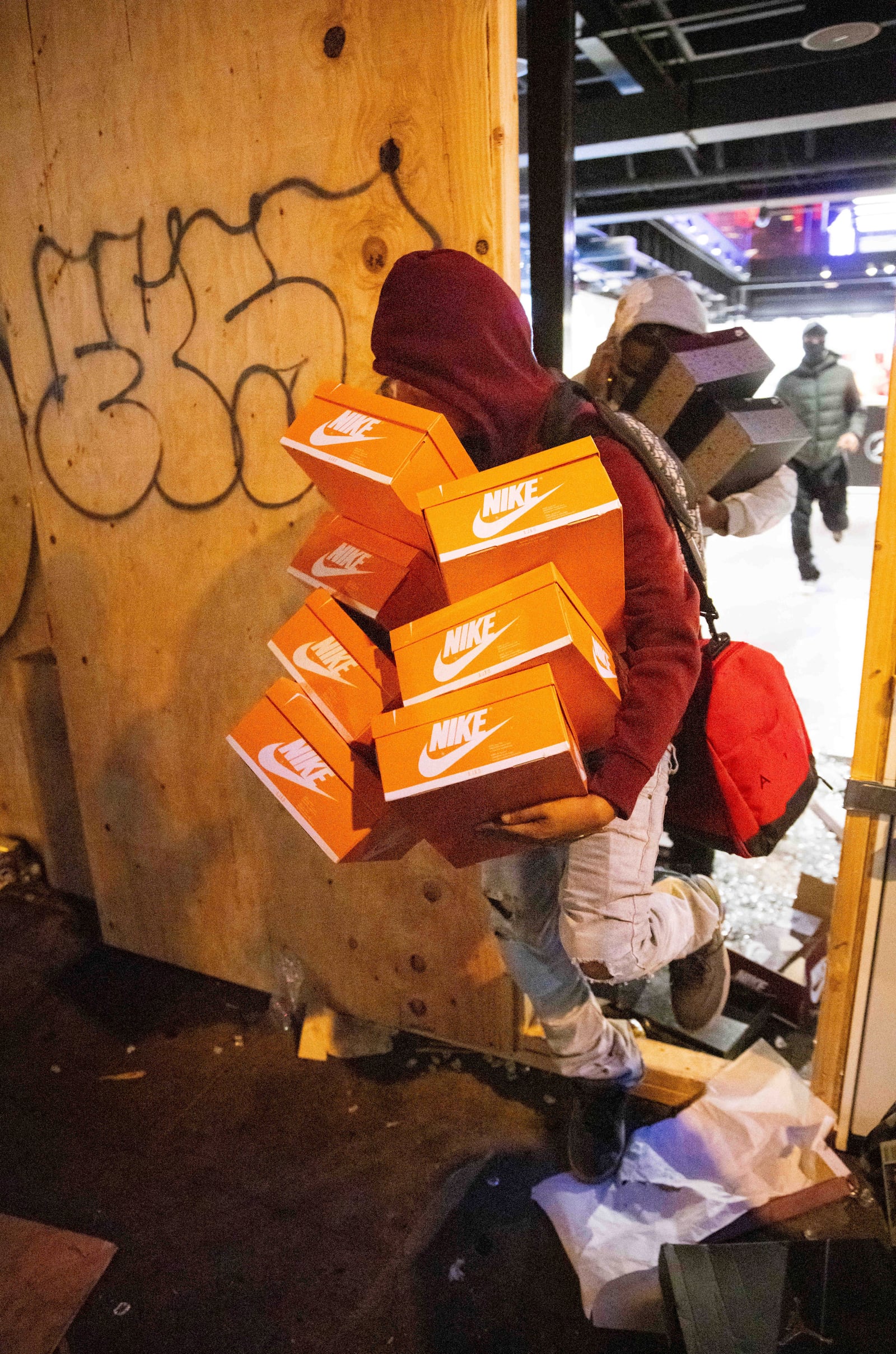 A person carries out items from a ransacked Nike store after the Los Angeles Dodgers defeated the New York Yankees to win the baseball World Series Wednesday, Oct. 30, 2024, in Los Angeles. (AP Photo/Ethan Swope)