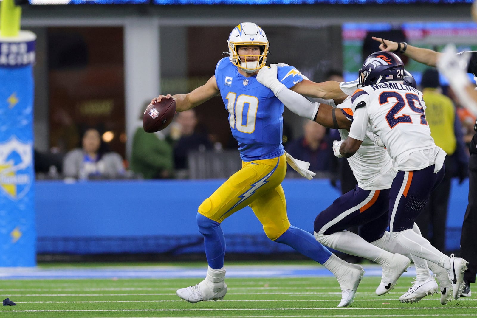 Los Angeles Chargers quarterback Justin Herbert (10) his pressured as he rolls out of the pocket during the second half an NFL football game against the Denver Broncos, Thursday, Dec. 19, 2024, in Inglewood, Calif. (AP Photo/Ryan Sun)