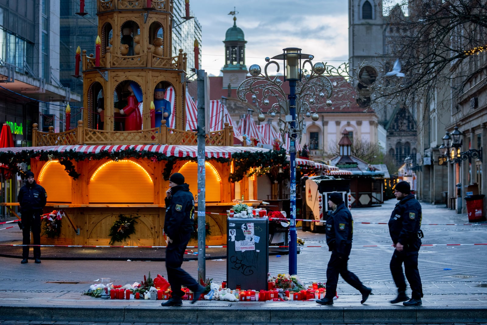 Policemen walk past the Christmas Market, where a car drove into a crowd on Friday evening, in Magdeburg, Germany, is empty on Sunday morning , Dec. 22, 2024. (AP Photo/Michael Probst)