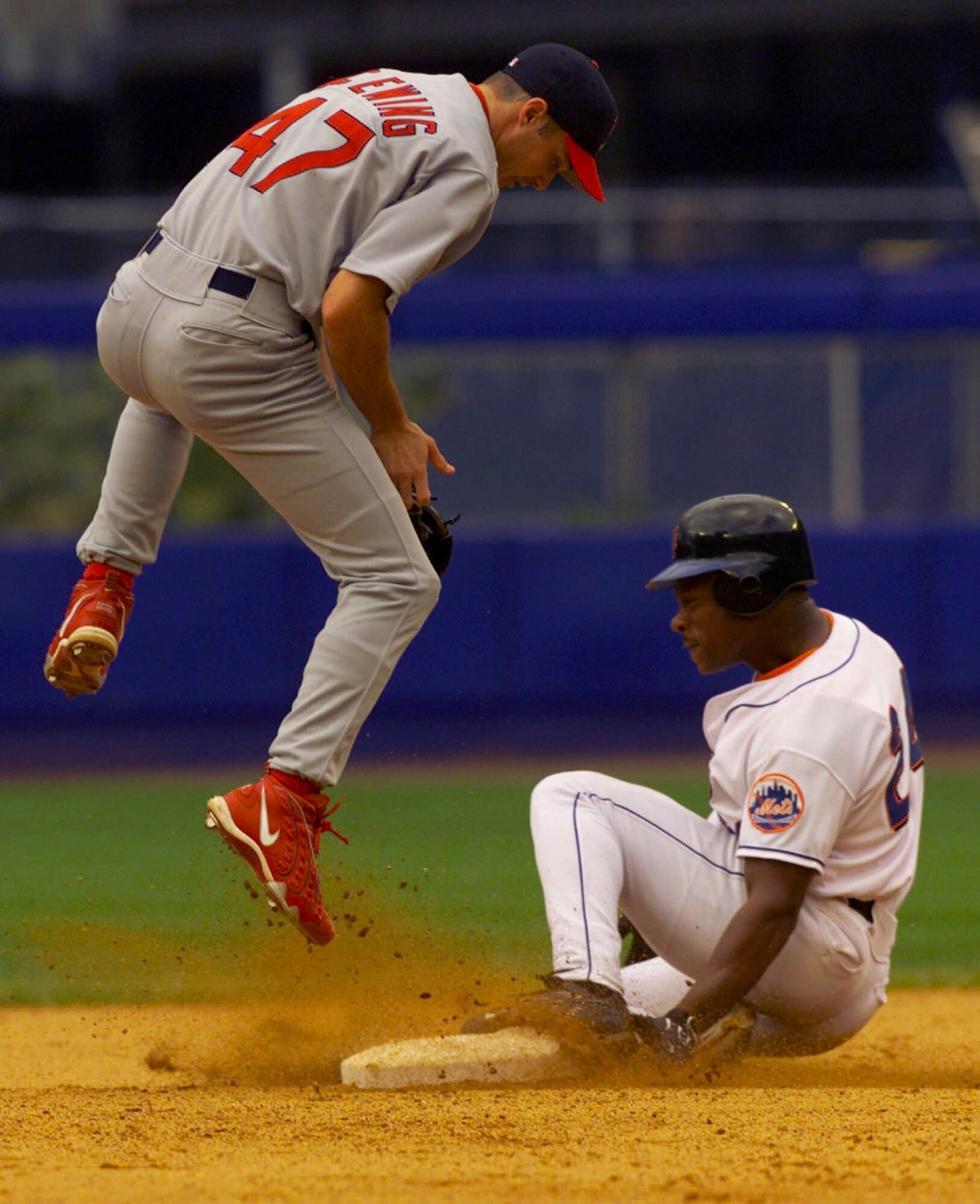 FILE - New York Mets' Rickey Henderson, right, slides safely into second base with his 30th stolen base of the year as St. Louis Cardinals second baseman Joe McEwing jumps while taking a late throw in the fourth inning of the first baseball game of a doubleheader Aug. 22, 1999, at Shea Stadium in New York. (AP Photo/Kathy Willens, File)