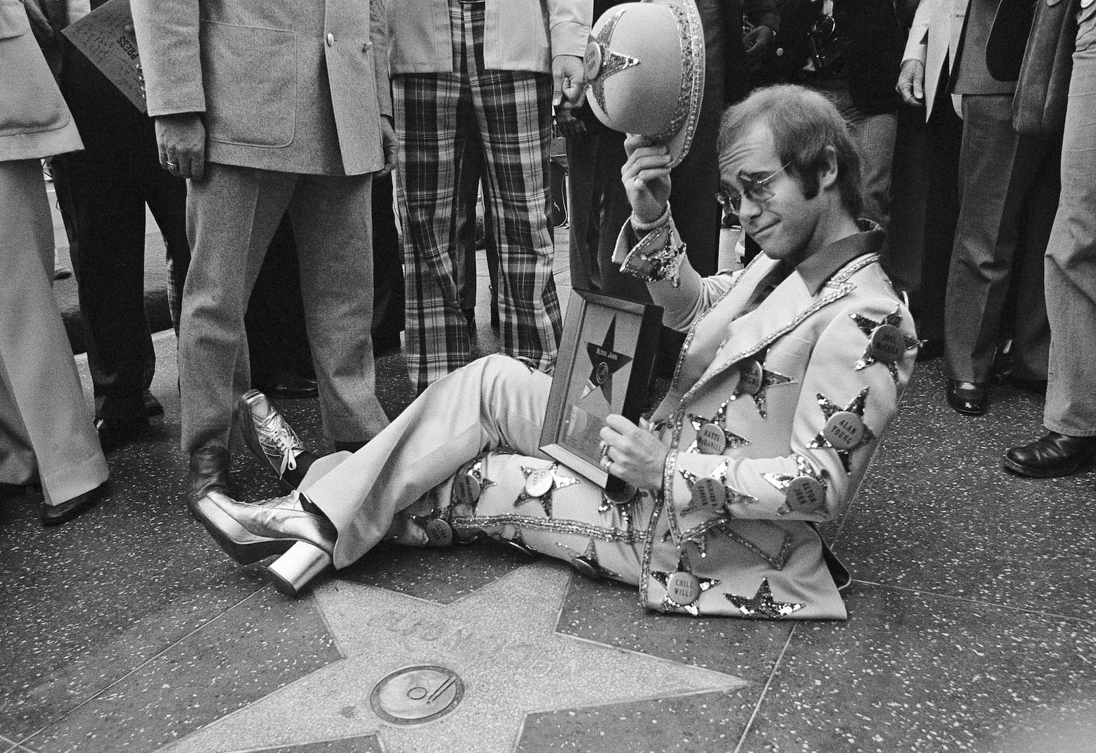 FILE - Elton John poses at his star on the Walk of Fame in Los Angeles on Oct. 23, 1975. (AP Photo/Jeff Robbins, File)