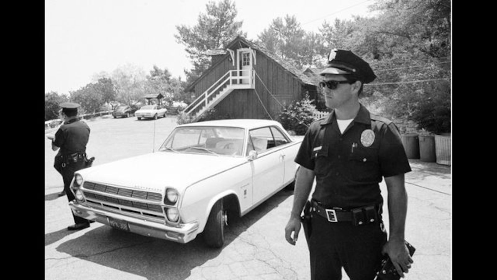 A police officer stands in front of the AMC Rambler in which the body of Steven Parent, 18, was found on the morning of Aug. 9, 2019. Parent was one of five people killed at 10050 Cielo Drive in Los Angeles by members of the Manson family. Photo: Getty Images