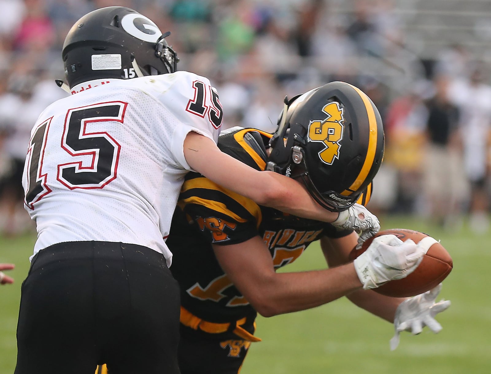 Shawnee’s Pete Mueller holds onto a touchdown pass even with Greenon’s Clay Hough’s arm in his facemask during Friday’s season opener. BILL LACKEY/STAFF