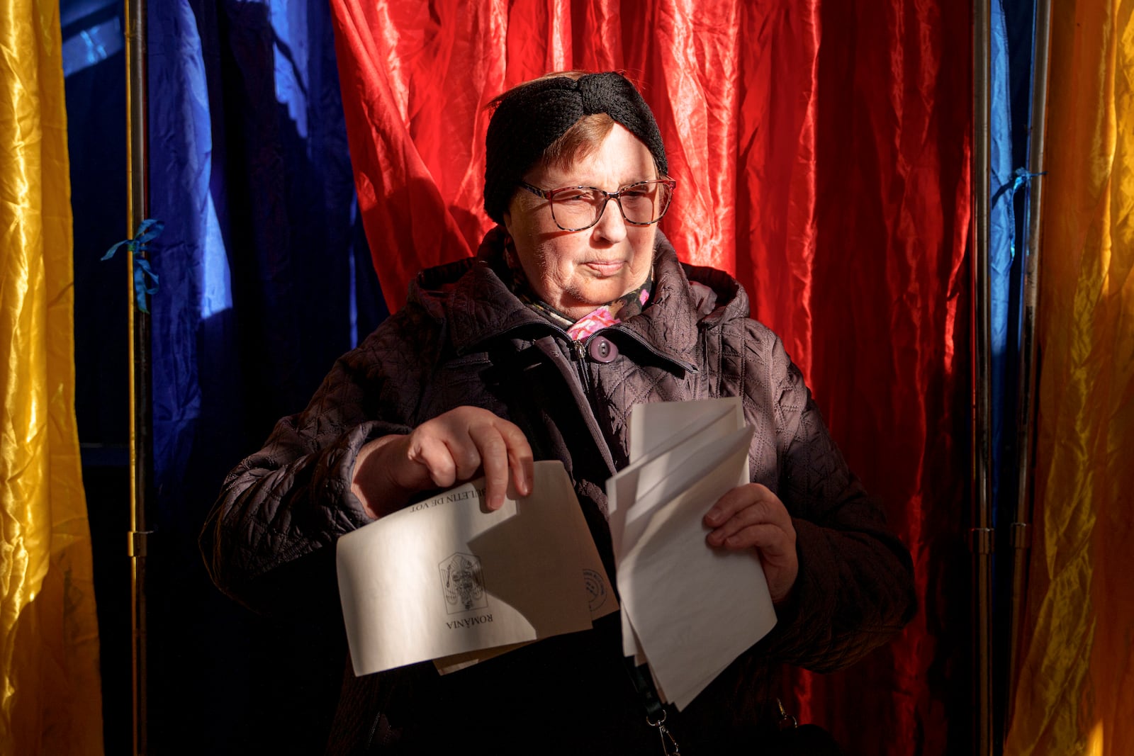 A woman exits a voting booth before casting her vote in the country's presidential elections, in Bucharest, Romania, Sunday, Nov. 24, 2024. (AP Photo/Andreea Alexandru)