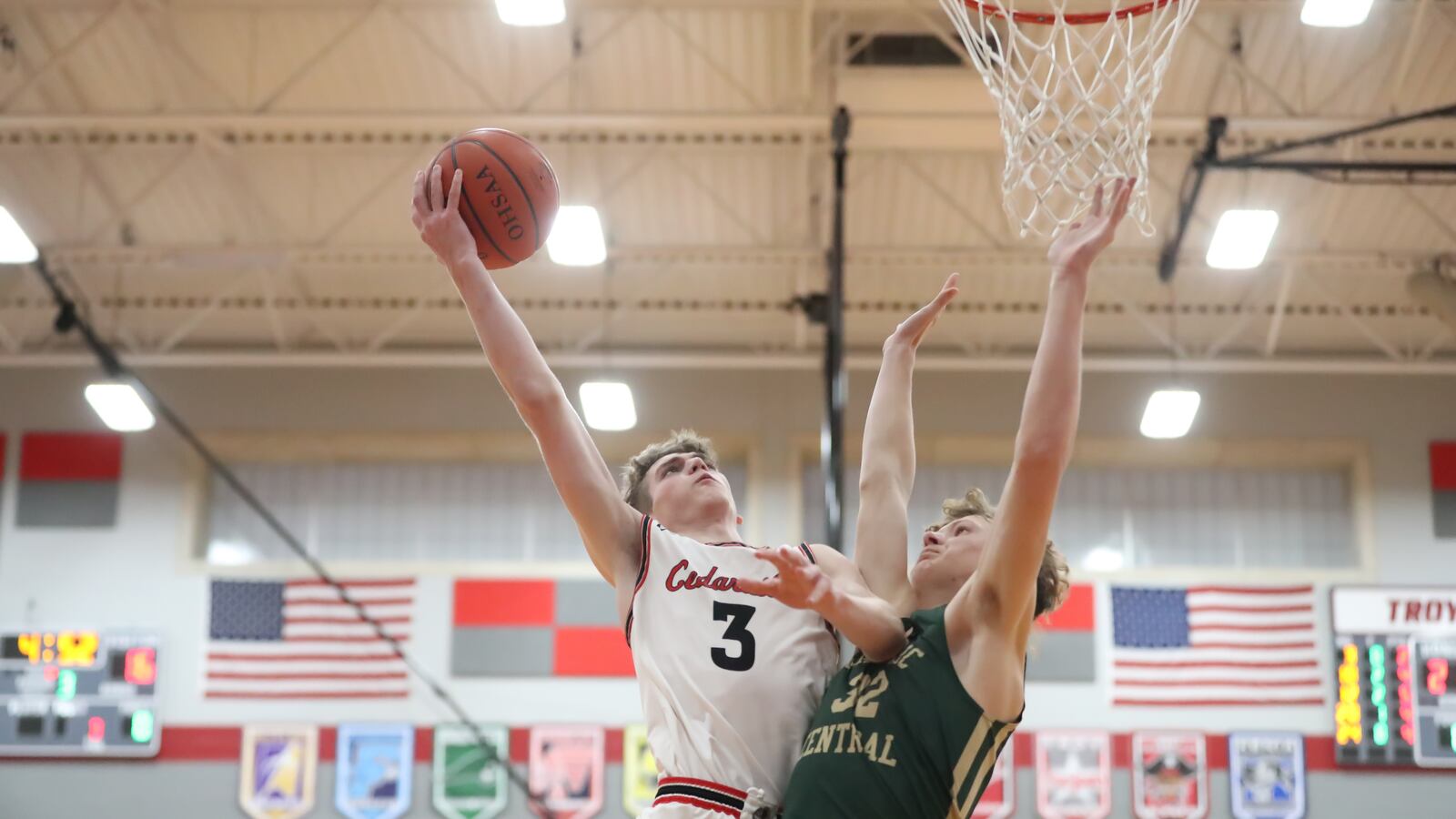 Cedarville senior Drew Koning shoots the ball over Catholic Central freshman Keegan Guenther during their D-IV district semifinal game on Saturday night at Troy High School. CONTRIBUTED PHOTO BY MICHAEL COOPER