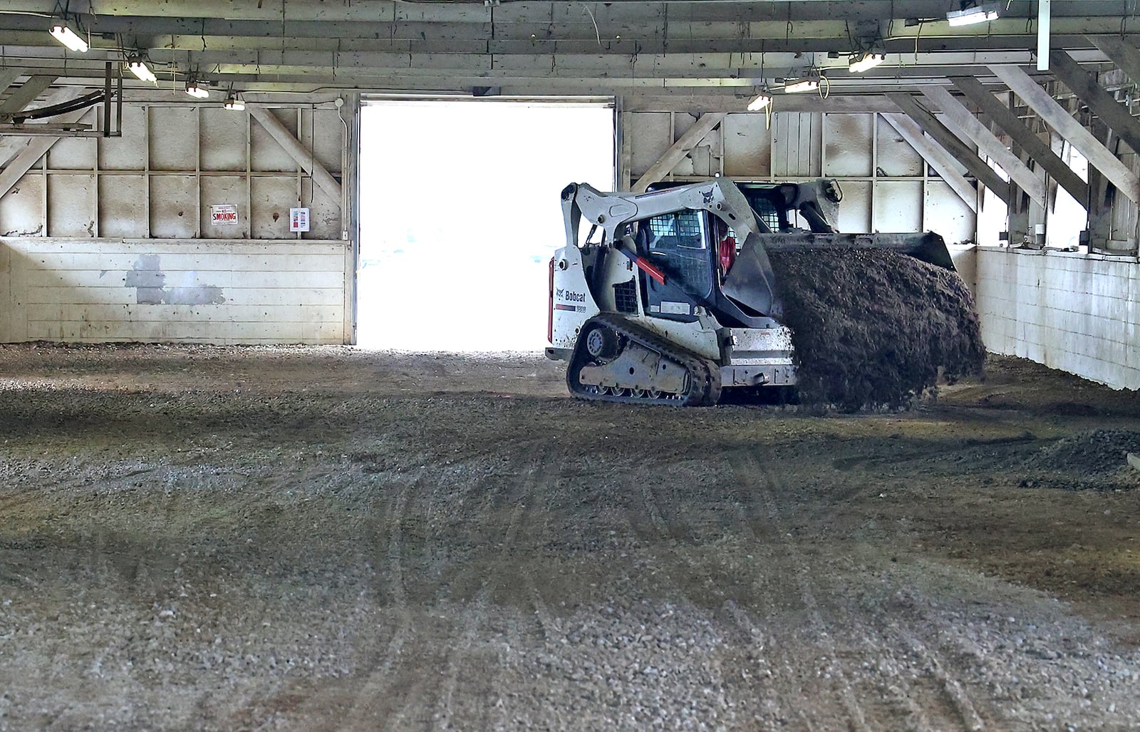 A work crew at the Clark County Fairgrounds puts down new gravel for the floor of the Goat Barn Friday as they get ready for the upcoming fair. BILL LACKEY/STAFF