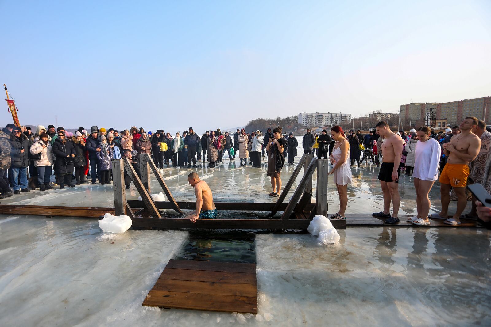 People plunge in icy water to celebrate the Orthodox Epiphany near the St. Serafimovsky Monastery on Russian Island in Russian far east port Vladivostok, Russia, Sunday, Jan. 19, 2025. (AP Photo)