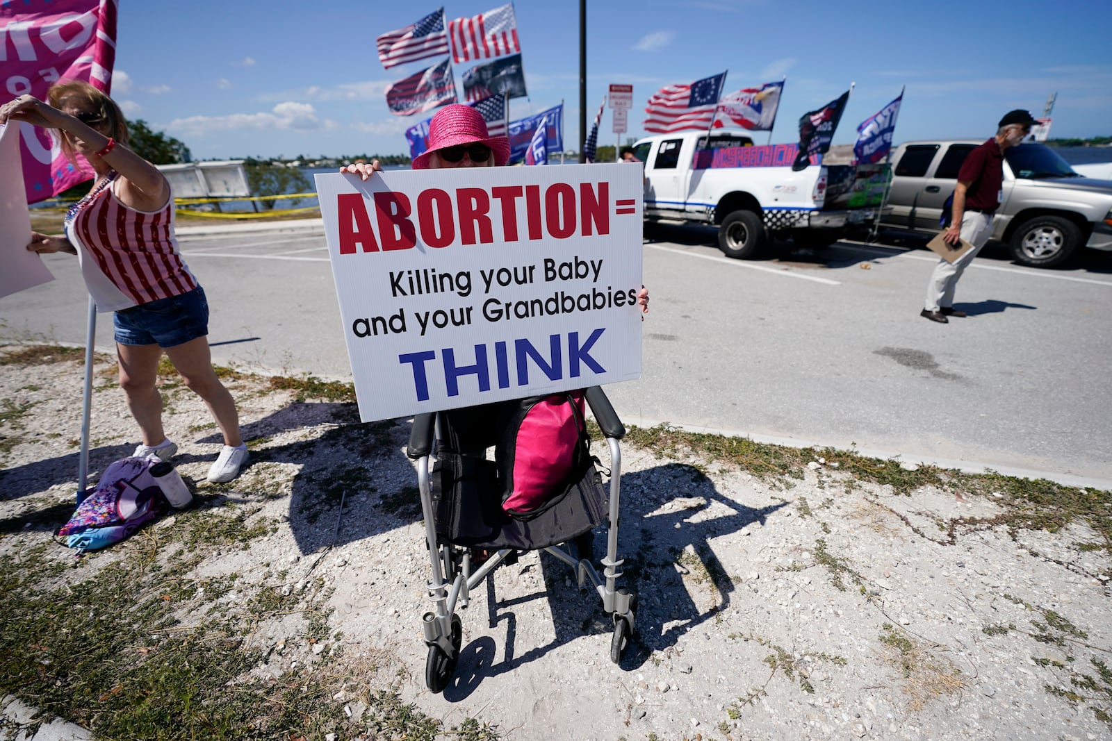 FILE - Leona Mangan of Lakeworth, Fla., holds a sign as she gathers with other supporters of former President Donald Trump outside his Mar-a-Lago estate in West Palm Beach, Fla., March 21, 2023. (AP Photo/Gerald Herbert, file)