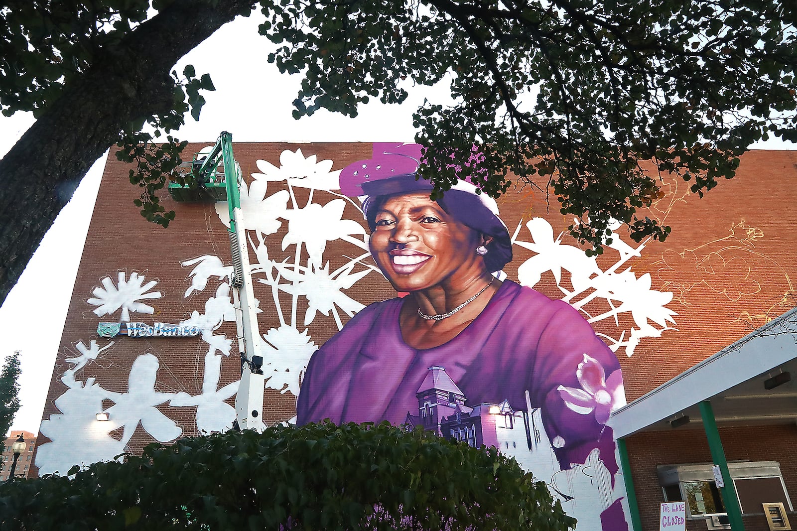 Muralist Gaia, from New York City, works on the mural of Springfield civil rights advocate Hattie Moseley on Thursday, Oct. 6, 2022 on the side of the WesBanco building in downtown Springfield. BILL LACKEY/STAFF