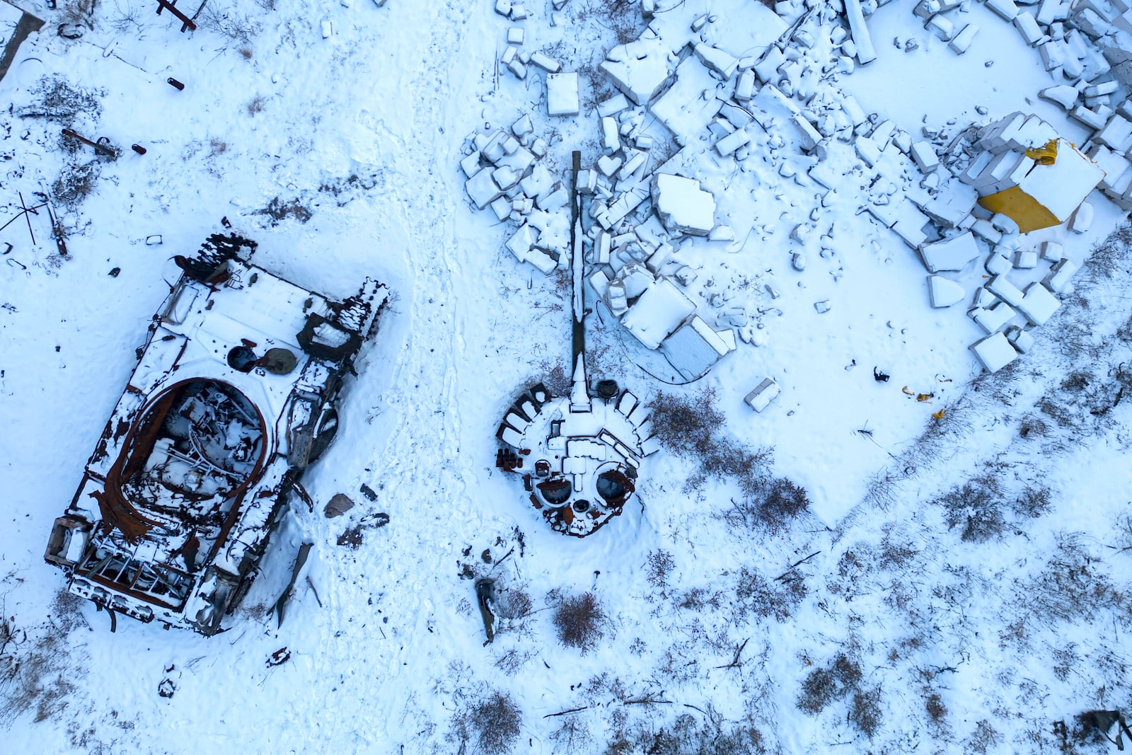 FILE - A destroyed Russian tank, covered in snow, stands in the yard of a private house in the town of Sviatohirsk, Ukraine, Sunday, Feb. 12, 2023. (AP Photo/Evgeniy Maloletka, File)