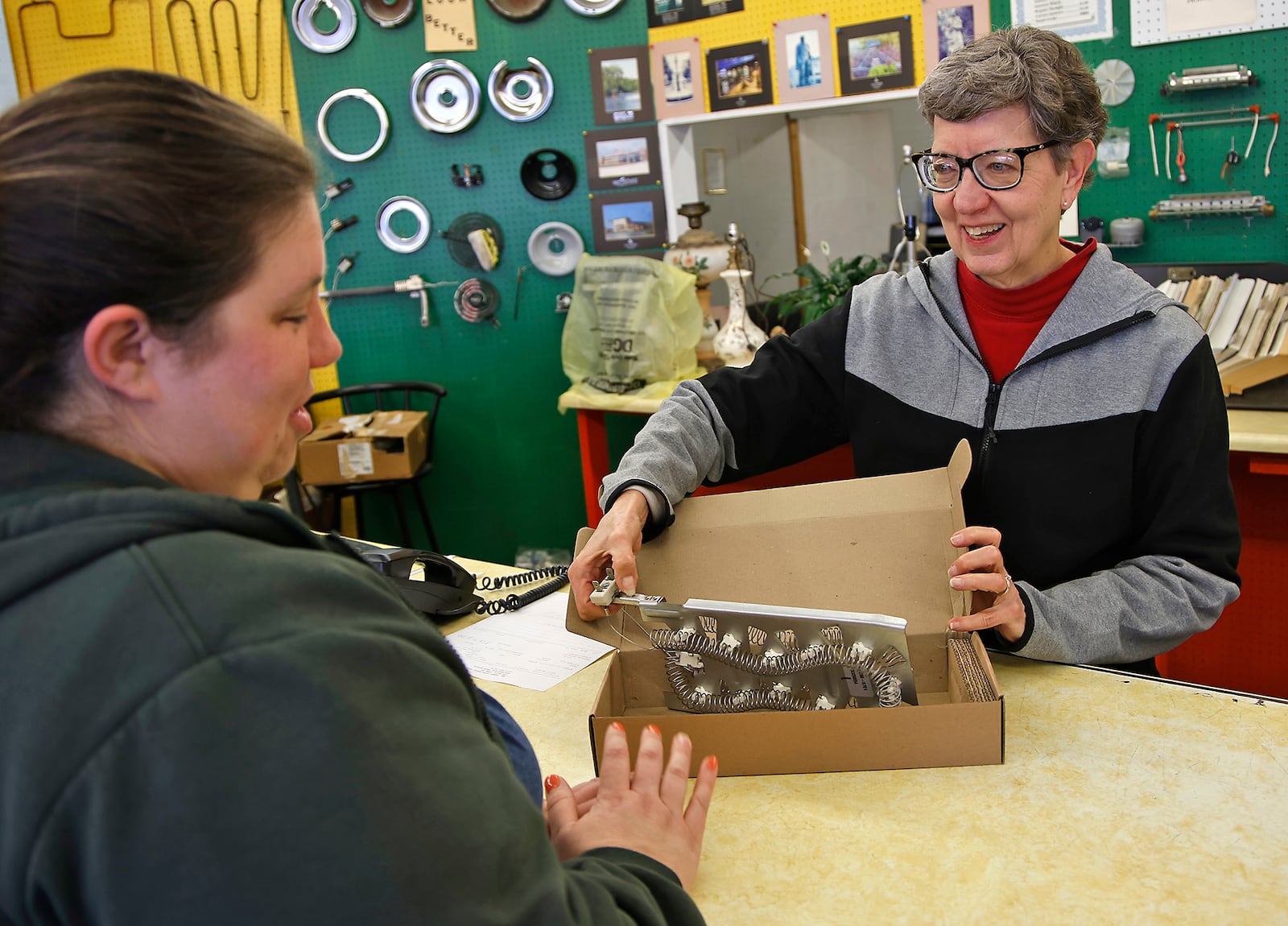 Bonnie Proper, the owner of Mr. Handy Appliance Parts Center, show Erin Sweitzer the heating element for her clothes dryer she ordered Thursday, Jan. 11, 2024. Erin has been coming into the Mr. Handy parts store and working with Bonnie since she was a young girl. BILL LACKEY/STAFF