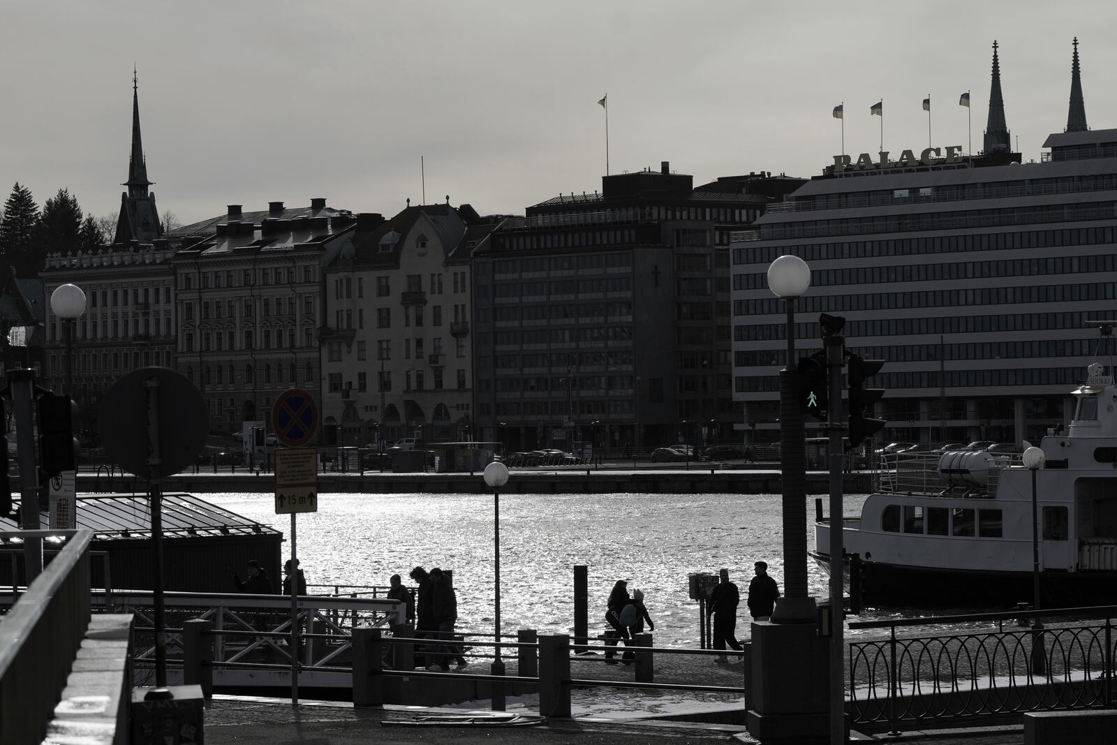 People walk on the embankment of the South Harbour in the center of Helsinki, Finland, Saturday, March 15, 2025. (AP Photo/Sergei Grits)