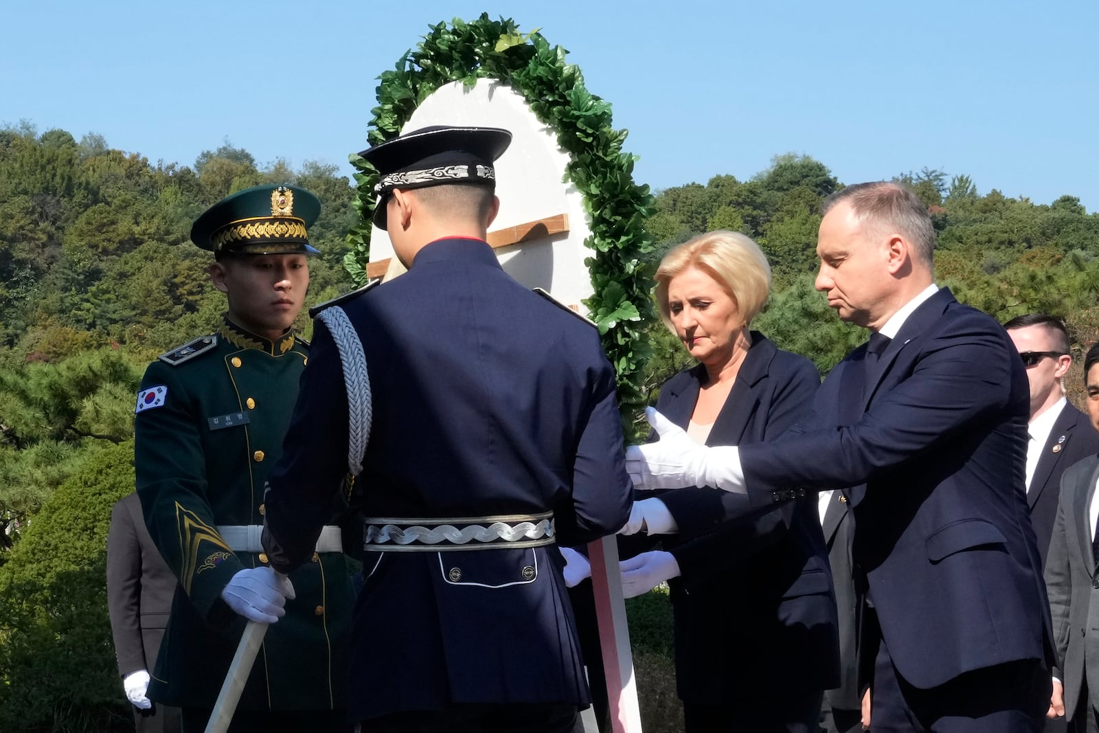 Polish President Andrzej Duda, right, and his wife Agata Kornhauser-Duda offer a wreath at the National Cemetery in Seoul, South Korea, Thursday, Oct. 24, 2024. (AP Photo/Ahn Young-joon)