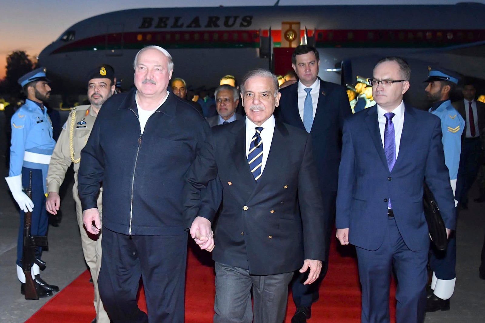 In this photo released by Press Information Department, Pakistan's Prime Minister Shehbaz Sharif, center, greets Belarusian President Alexander Lukashenko, left, upon his arrival at an airbase in Rawalpindi, Pakistan, Monday, Nov. 25, 2024. (Press Information Department via AP)