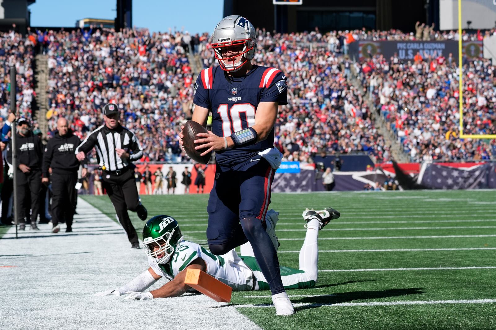 New England Patriots quarterback Drake Maye (10) runs into the end zone for a touchdown in front of New York Jets linebacker Chazz Surratt (55) in the first half of an NFL football game, Sunday, Oct. 27, 2024, in Foxborough, Mass. (AP Photo/Michael Dwyer)