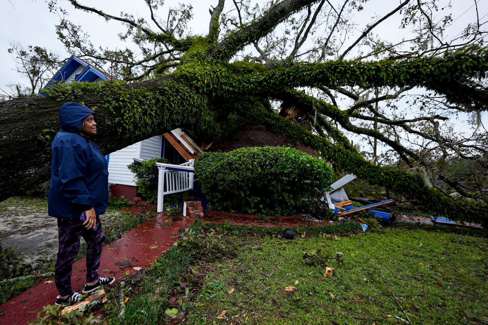 FILE - Rhonda Bell looks on after an Oak tree landed on her 100-year-old home after Hurricane Helene moved through, Friday, Sept. 27, 2024, in Valdosta, Ga. (AP Photo/Mike Stewart, File)