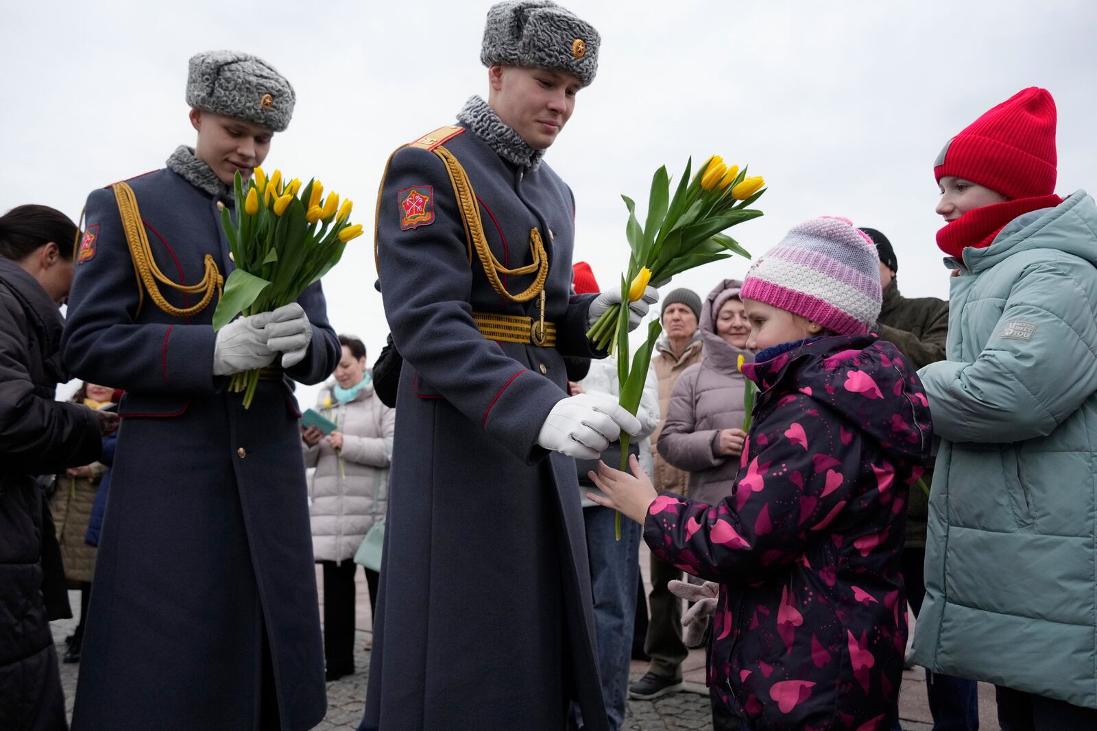 Honour guard soldiers present flowers to girls and women during International Women's Day celebration in St. Petersburg, Russia, Saturday, March 8, 2025. (AP Photo/Dmitri Lovetsky)