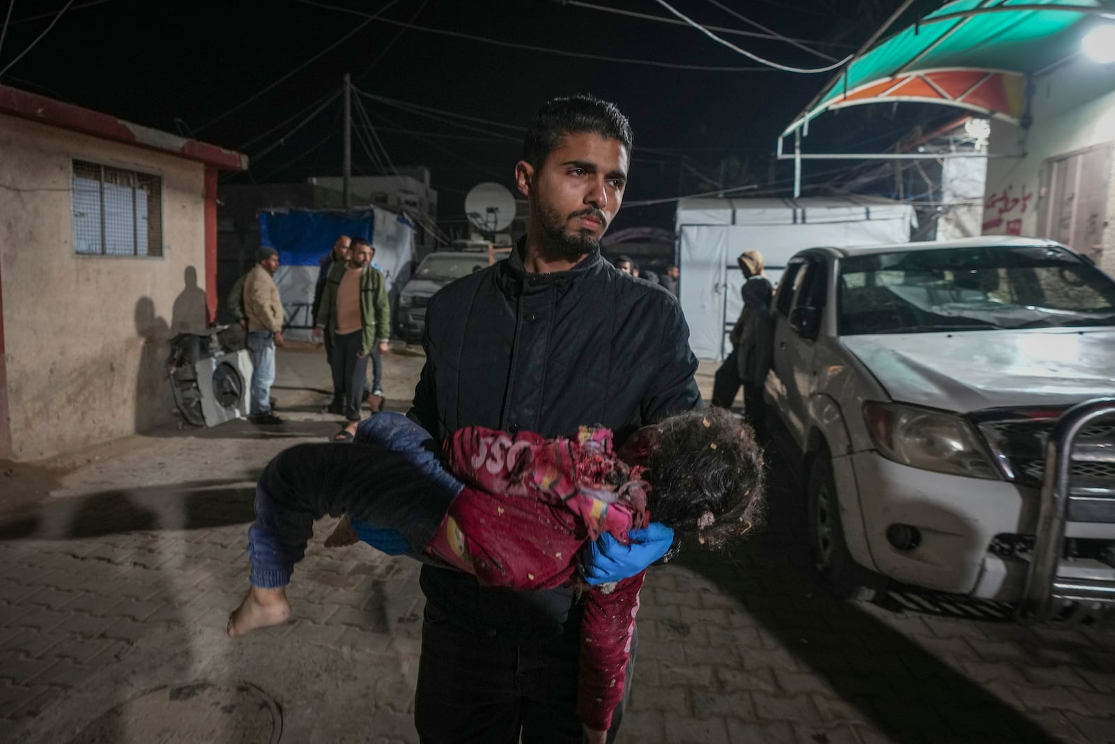 A dead child is carried into the Al-Aqsa Martyrs hospital in Deir al-Balah after an Israeli army strike in the Bureij refugee camp, central Gaza Strip, Saturday Dec. 14, 2024.(AP Photo/Abdel Kareem Hana)