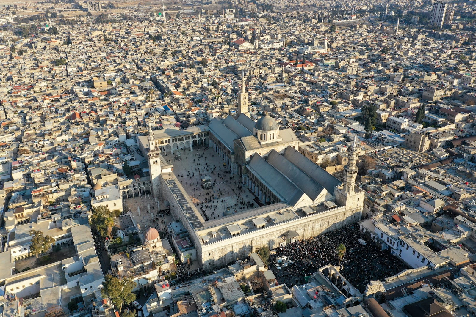 A crowd gathers outside the Umayyad Mosque during the distribution of free meals after Friday prayers in Damascus, Syria, Friday Jan. 10, 2025. (AP Photo/Ghaith Alsayed)