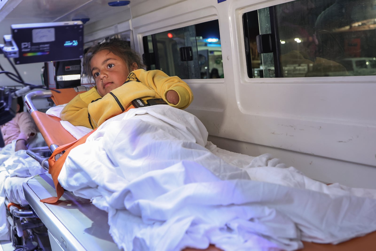 A Palestinian girl injured in the Israeli military's ground and air offensive on Gaza, sits in an ambulance as the first group of sick Gaza children arrives in Jordan for medical treatment at the King Hussein Bridge border crossing on Tuesday, March 4, 2025. (AP Photo/Raad Adayleh)