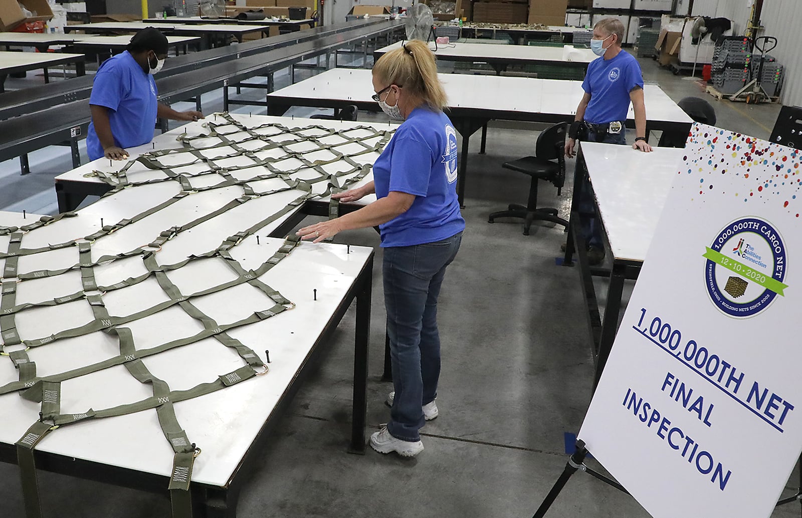 The Abilities Connection employees , from left, Jordan Johnson, Patricia Anderson and Russ Graham inspect the one millionth cargo net manufactured by the company. BILL LACKEY/STAFF