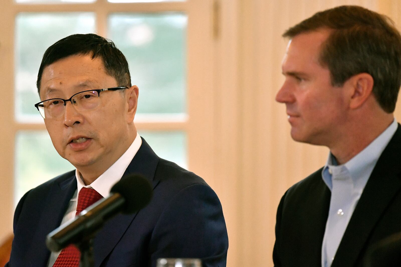 Kentucky Governor Andy Beshear, right, listens, as Dr. Shawn Qu, Chairman and CEO of Canadian Solar speaks discusses the announcement by Shelbyville Battery Manufacturing of a $712 million battery manufacturing project in Shelbyville, Ky., creating 1,572 skilled, high-tech jobs at the Governor's Mansion in Frankfort, Ky., Friday, Nov. 15, 2024. (AP Photo/Timothy D. Easley)