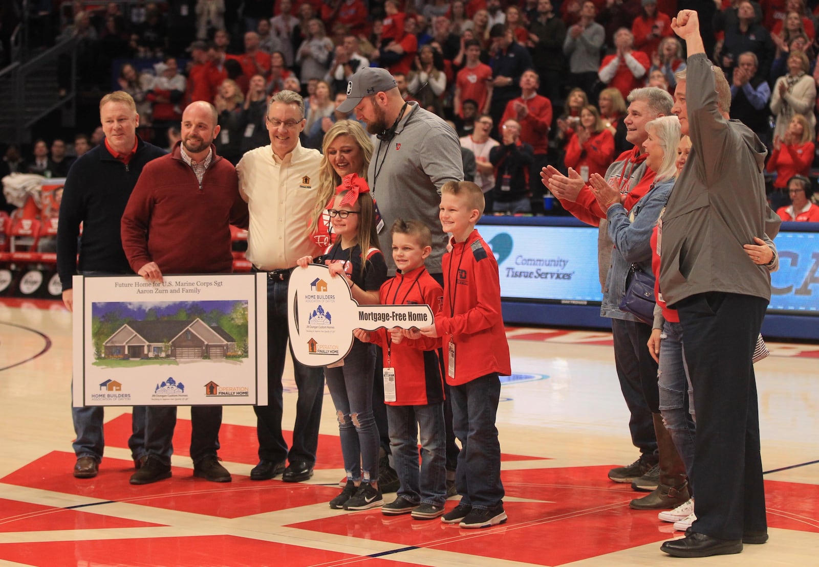 Aaron Zurn and his family are presented with a photo of a new home that will be built for them in Vandalia.