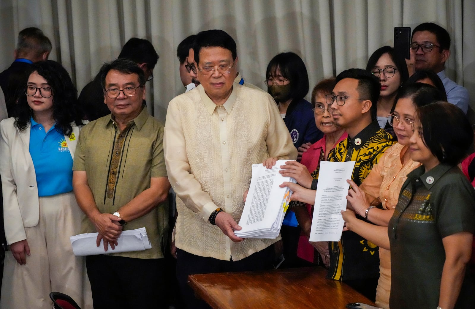 House Secretary General, Reginald Velasco, center, receives a second impeachment complaint filed against Philippine Vice President Sara Duterte by a group led by left-wing activists on Wednesday Dec. 4, 2024 at the House of Representatives in Quezon City, Philippines. (AP Photo/Aaron Favila)