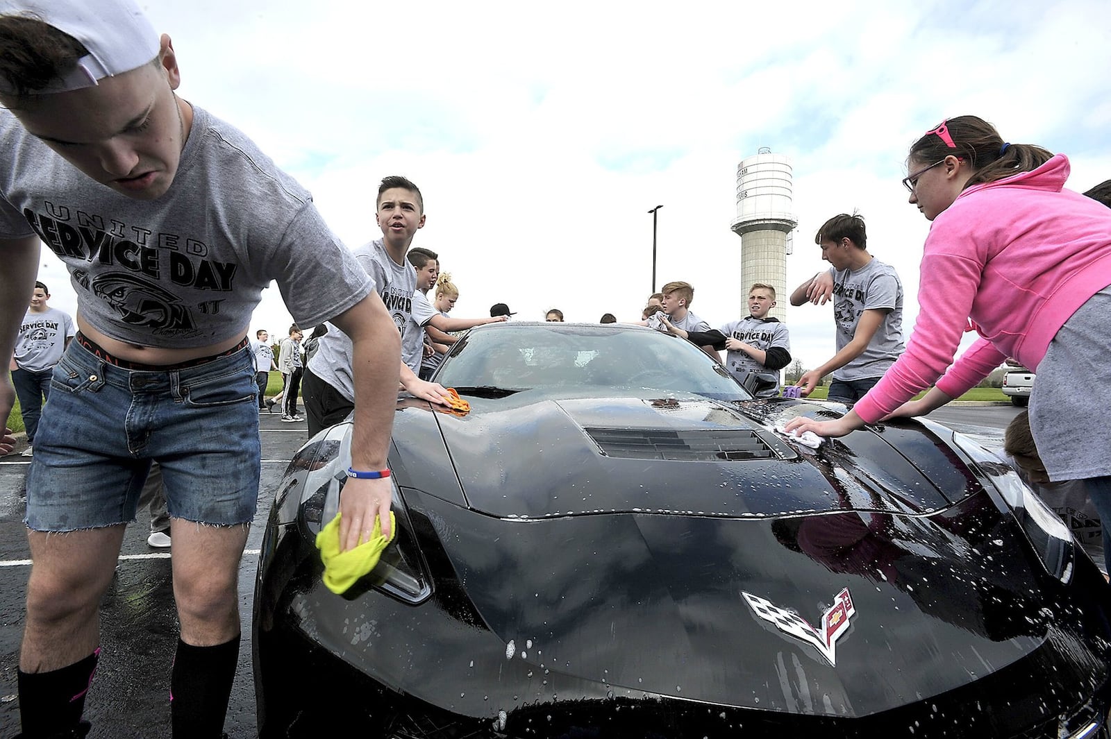 Graham Middle School students, including Nick Moore, left, wash cars Friday in the school parking lot for Service Day.