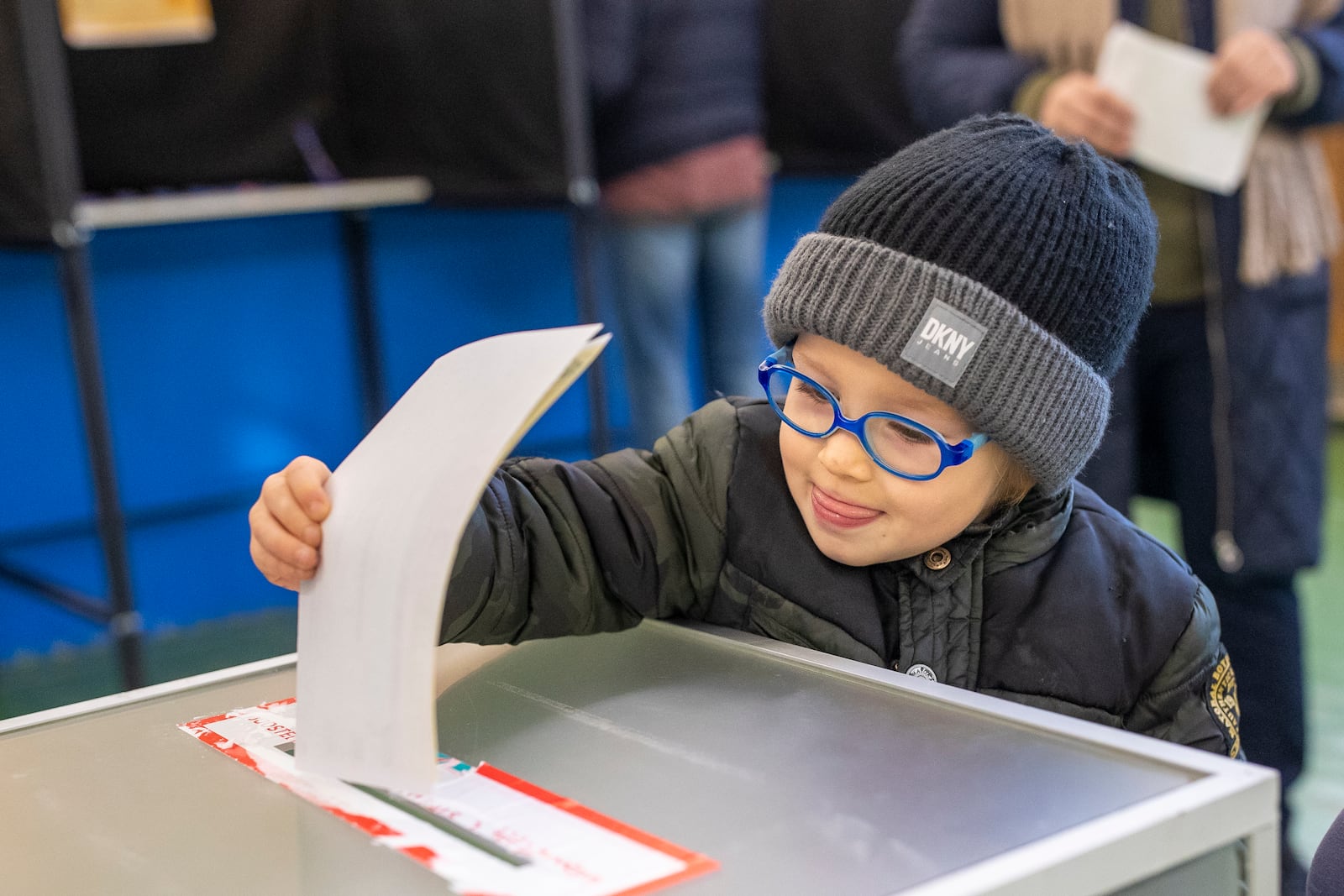 A boy casts a ballot at a polling station during the first round of voting in parliamentary election, in Vilnius, Lithuania, Sunday, Oct. 13, 2024. (AP Photo/Mindaugas Kulbis)