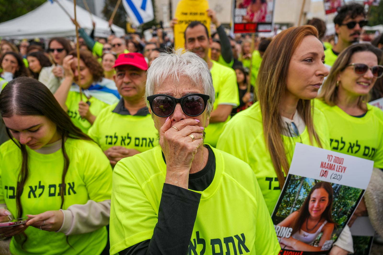 Relatives and friends of Israeli people killed and abducted by Hamas and taken into Gaza follow the news of the hostages' release as they gather in Tel Aviv, Israel, Saturday, Jan. 25, 2025. (AP Photo/Ariel Schalit)